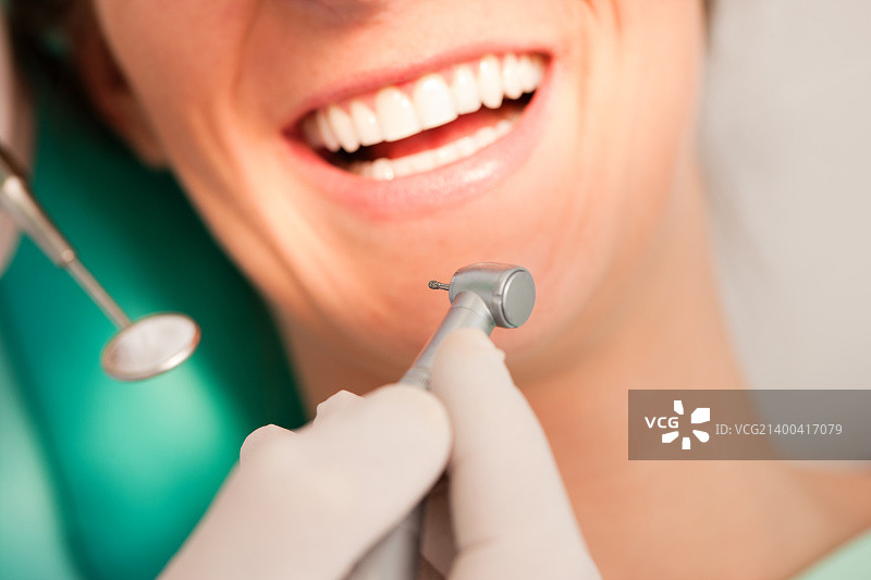 牙科治疗过程中与牙医在一起的女病人，聚焦牙钻图片素材