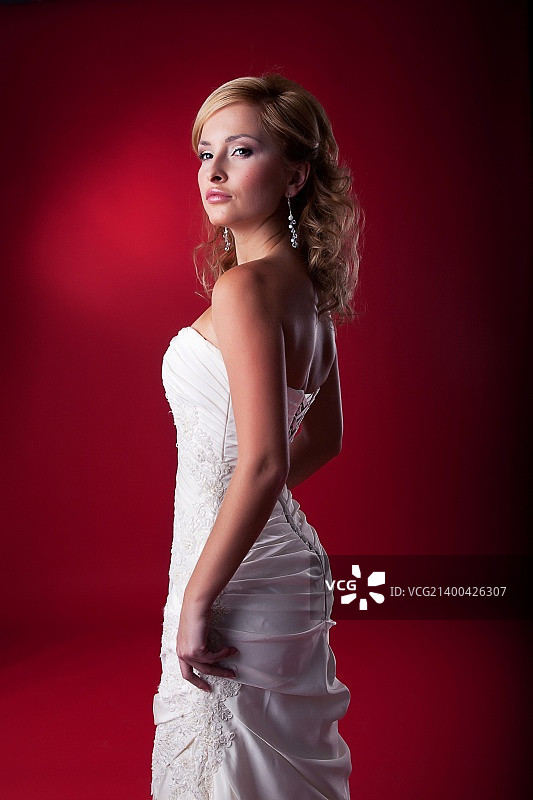 新娘——身穿白色婚纱站在讲台上的美丽金发婚礼模特图片素材