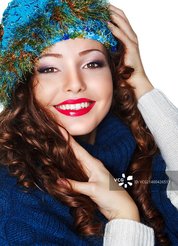 快乐微笑的黑发女子戴着蓝色针织帽和运动衫图片素材