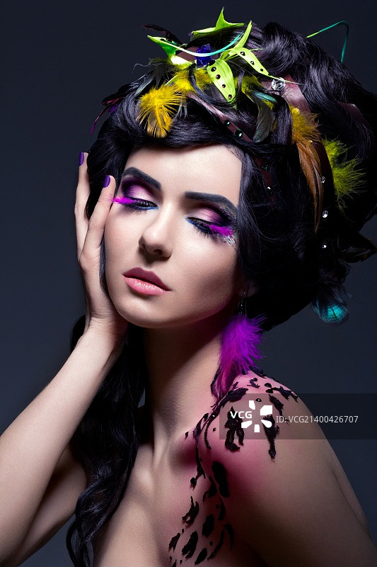 奇幻风格：色彩鲜艳羽毛和妆容的时尚女性图片素材