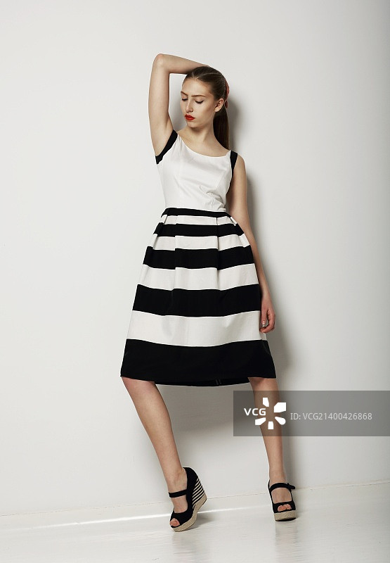 个性：自信的年轻女子身穿撞色连衣裙图片素材