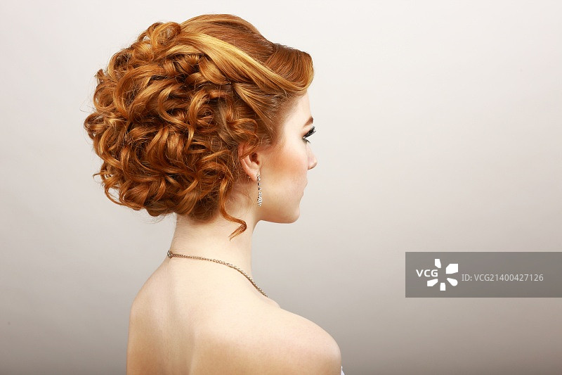造型。蓬乱红发女士的后视图。护发水疗沙龙概念图片素材