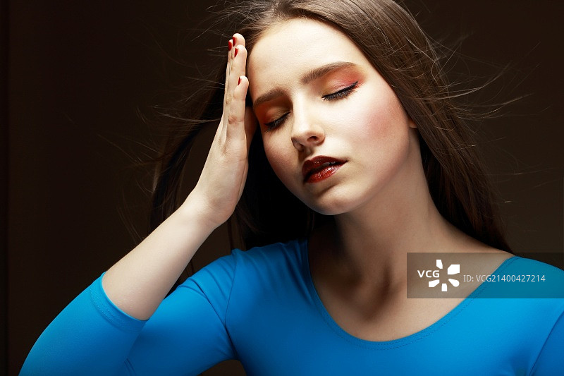 悲伤难过：疲惫的女人摸着额头图片素材