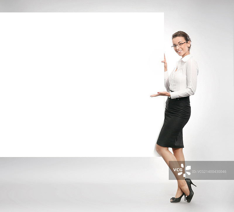 展示空白白板的迷人女商人图片素材