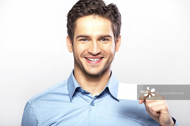 笑容灿烂的英俊男子展示名片图片素材