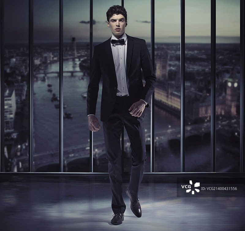摩天大楼顶上的严肃英俊的男子图片素材