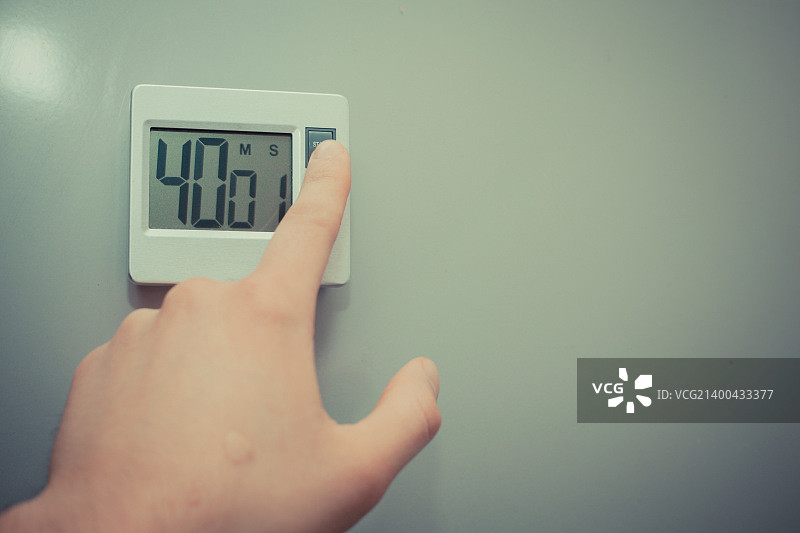 手在厨房里按下按钮启动定时器特写图片素材