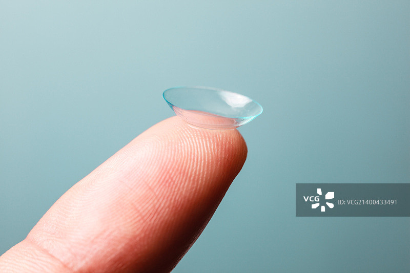 蓝色背景上的指尖隐形眼镜图片素材