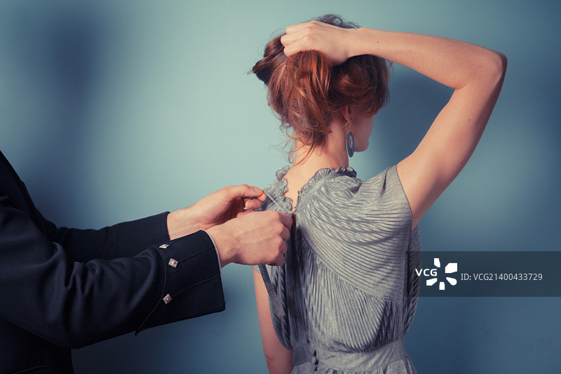 男人在为女人优雅的晚礼服系蝴蝶结图片素材