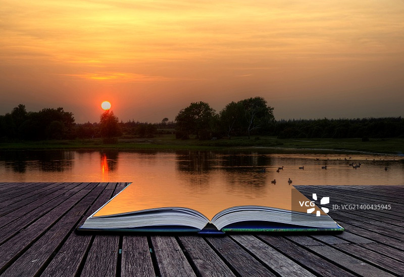 日落倒影唯美画面创意概念：魔法书映衬湖面倒影图片素材