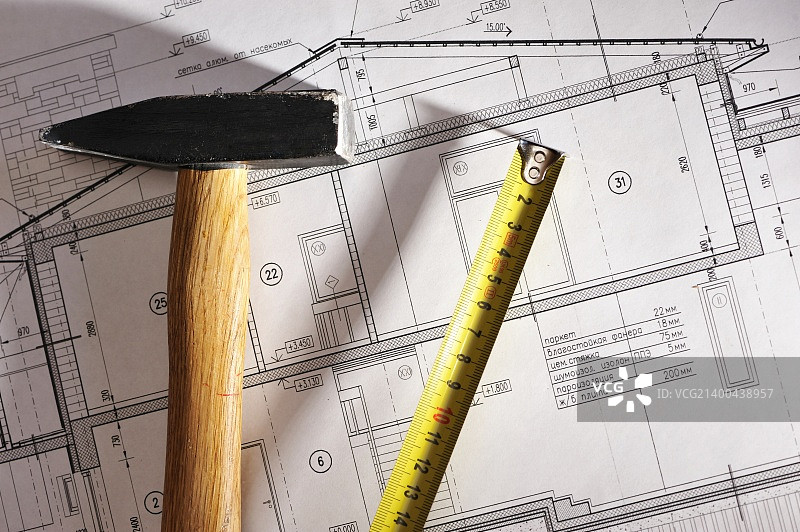 房屋蓝图上的锤子和卷尺图片素材