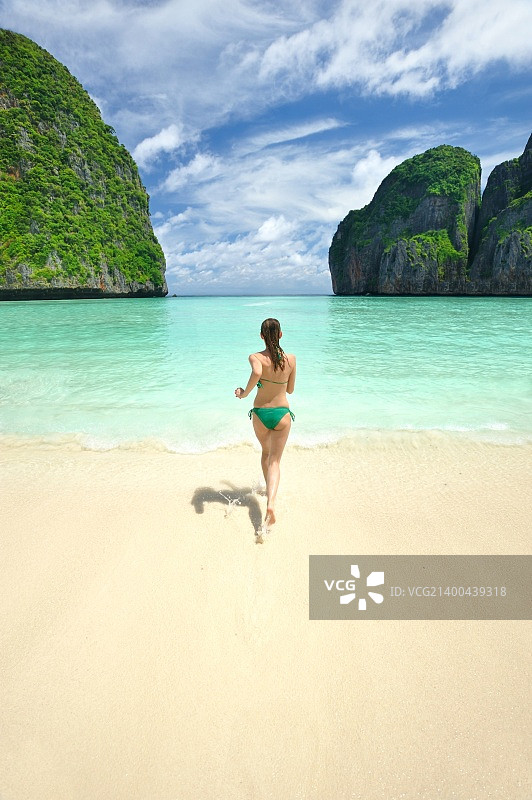 在皮皮岛美丽泻湖中奔跑的女人，电影《海滩》的拍摄地图片素材