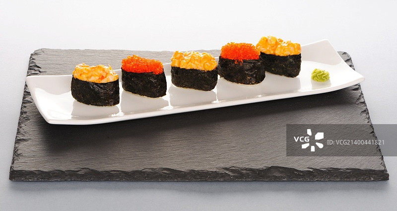 石板盘上的飞鱼籽和香料寿司图片素材
