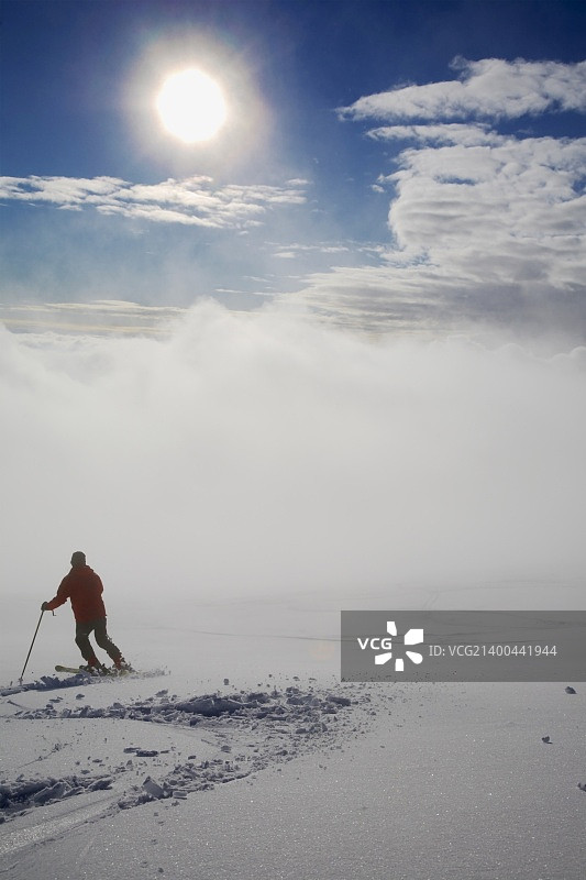滑雪坡上的年轻男滑雪者；背面图图片素材