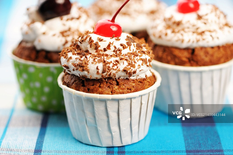 布上的奶油樱桃纸杯蛋糕图片素材