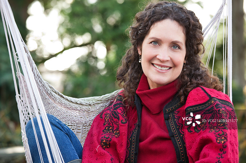 一位坐在吊床上的美丽中年妇女图片素材
