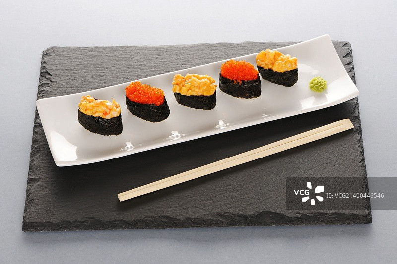石板盘上的飞鱼籽和香料寿司图片素材