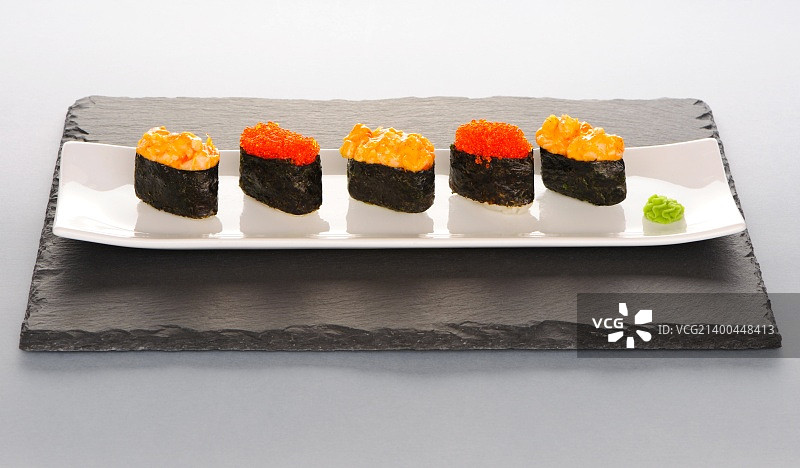 石板盘上的飞鱼籽和香料寿司图片素材