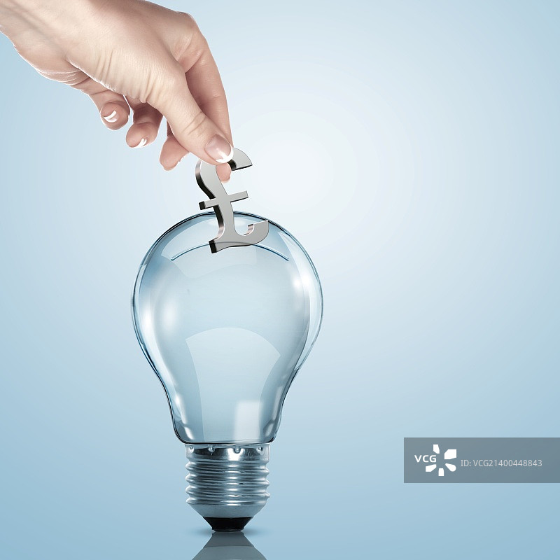 手和灯泡里的钱图片素材