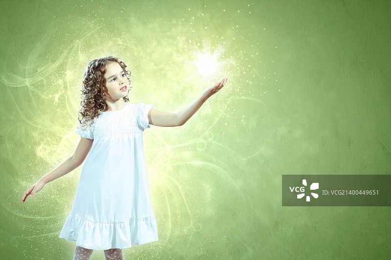 被魔法光芒环绕的小女孩图片素材