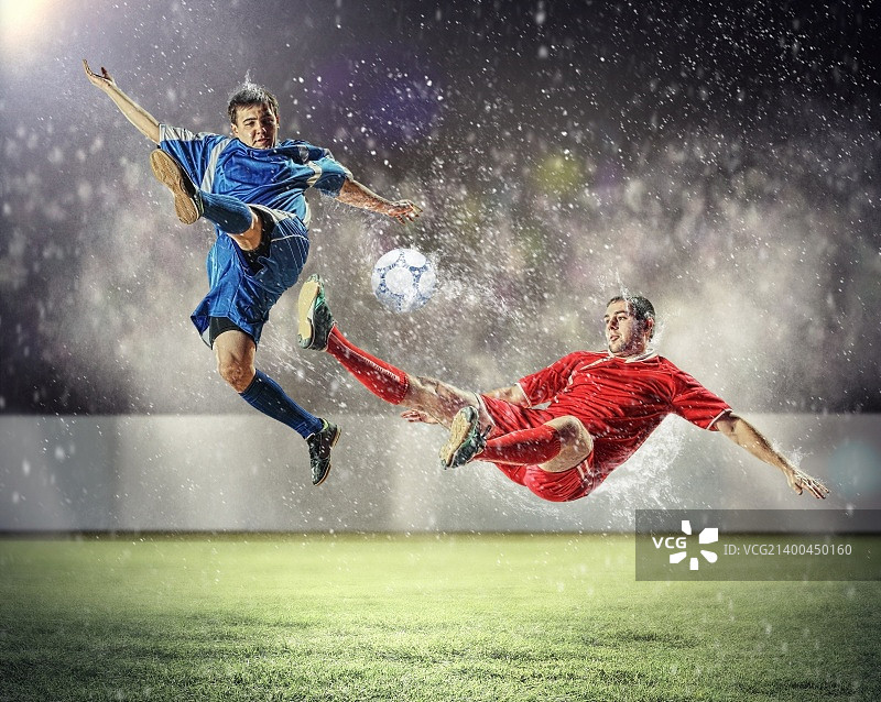 两名足球运动员跳跃踢球图片素材