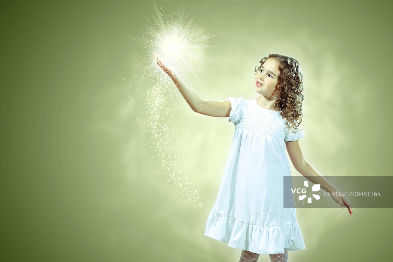 被魔法光芒环绕的小女孩图片素材