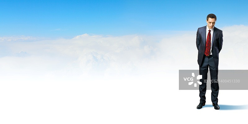 身穿西装的年轻商人，以蓝天为背景图片素材