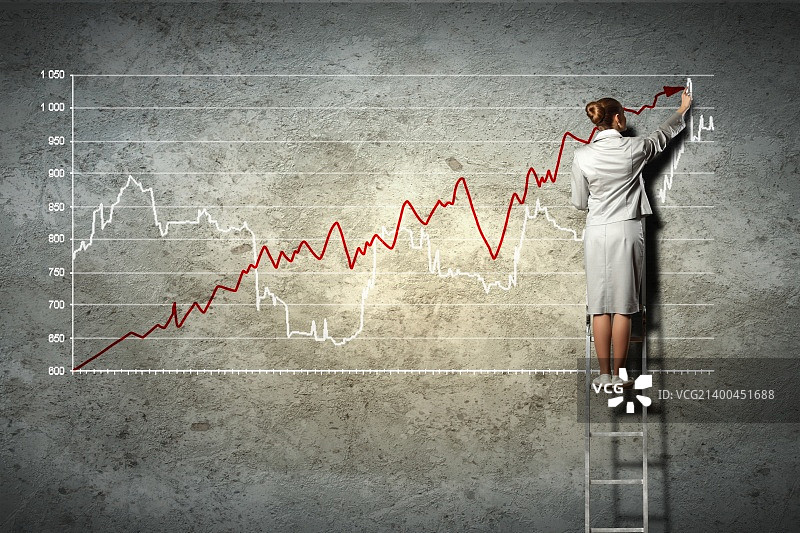 女商人站在梯子上在墙上绘制图表图片素材