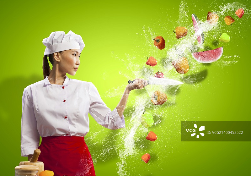 用刀切水果和蔬菜的亚洲女厨师图片素材