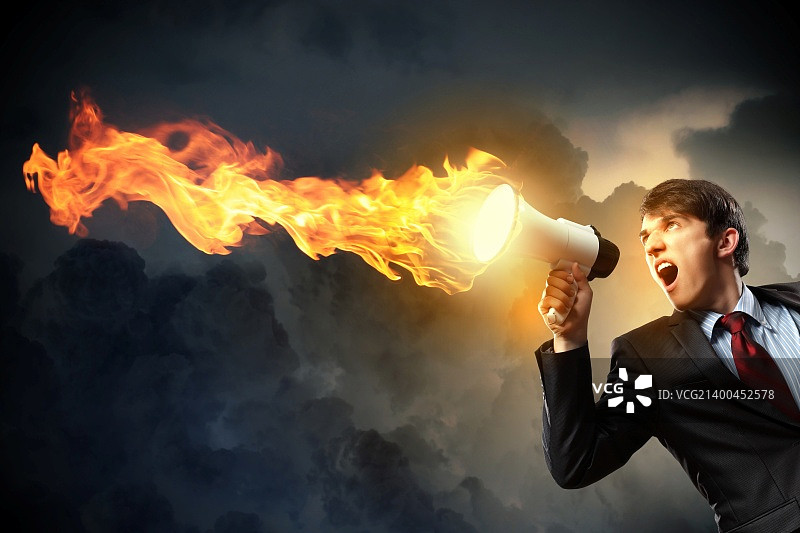 身穿黑色西装的年轻商人对着扩音器尖叫图片素材