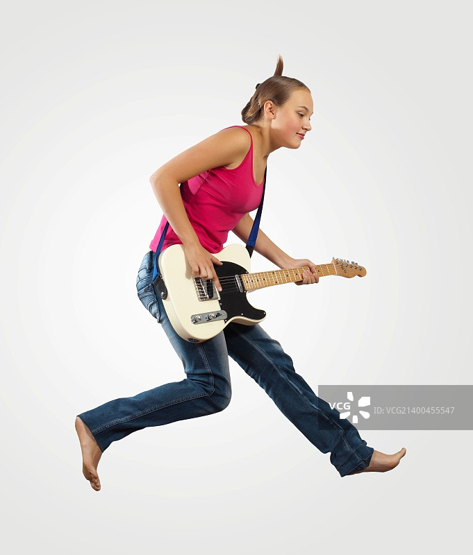 年轻女人弹电吉他跳跃图片素材