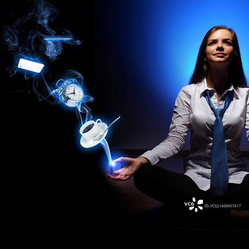 年轻女商人坐在蓝色背景前，显示时钟界面图片素材