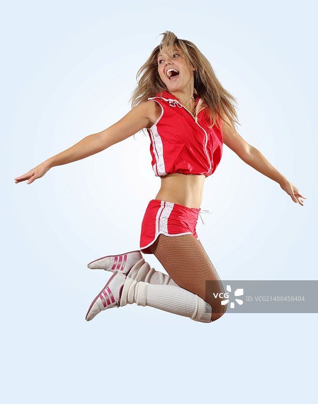 身穿制服的啦啦队员高高跳起（白色背景）图片素材
