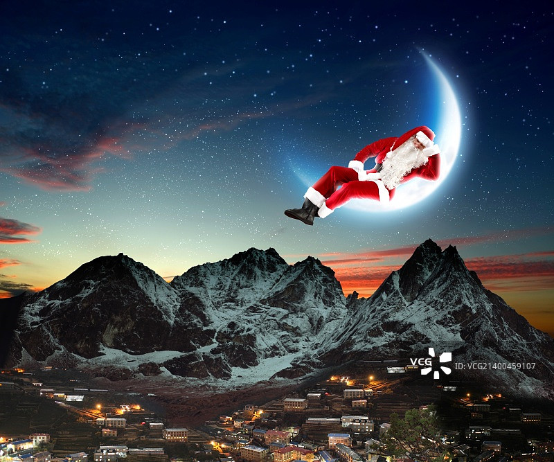 圣诞老人坐在月亮上，下方是城市和山脉的照片图片素材