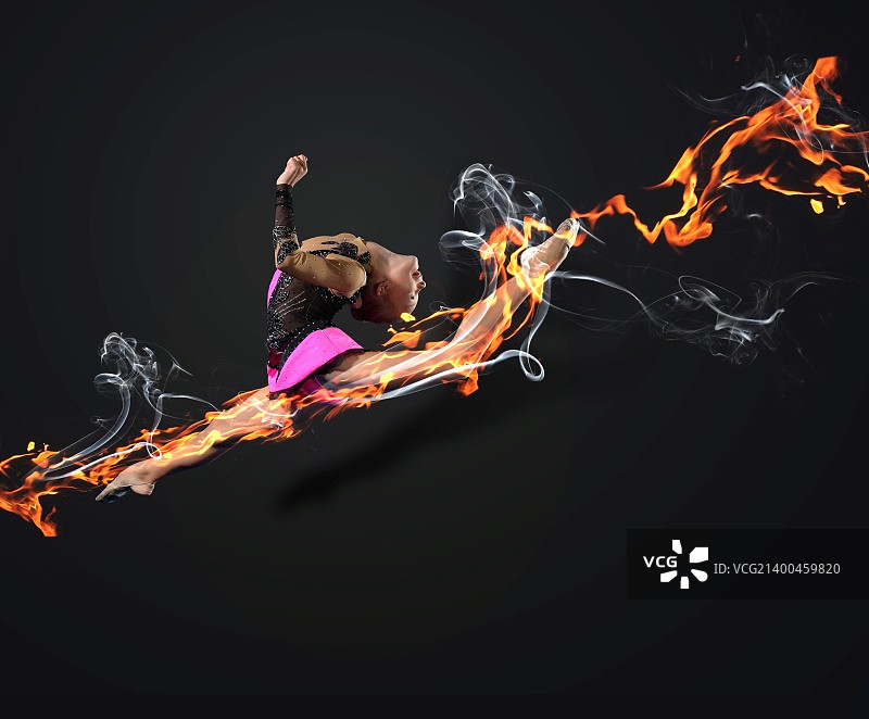 穿着体操服的年轻可爱女子在黑色背景上展示运动技巧图片素材