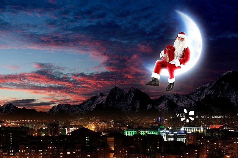 圣诞老人坐在月亮上，下方是城市和山脉的照片图片素材