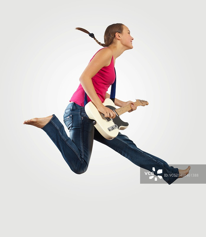 年轻女人弹电吉他跳跃图片素材