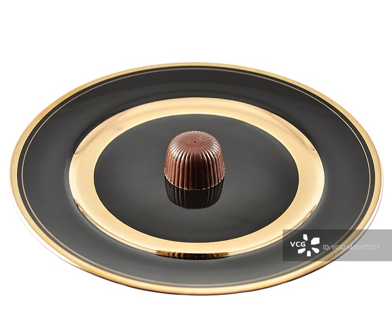 白色背景黑色盘子上的巧克力糖果图片素材