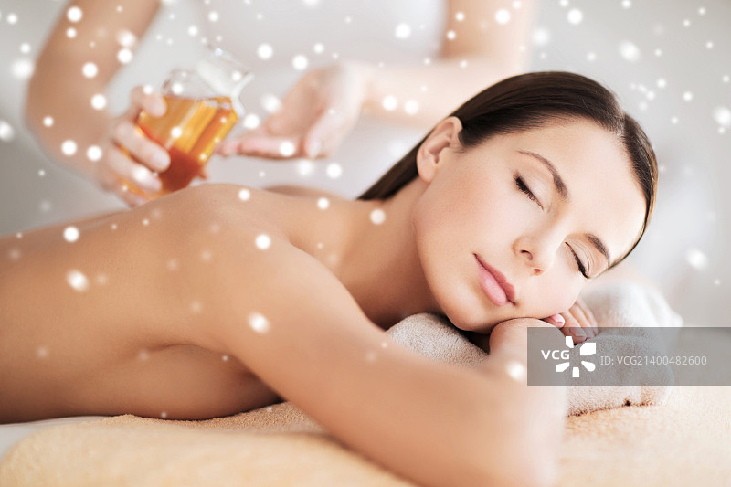 美容、健康、人物与水疗概念：在水疗沙龙按摩台上美丽的年轻女子图片素材