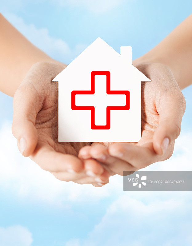 医疗保健、医药和慈善概念 - 手拿带有红十字标志的白色纸房子图片素材