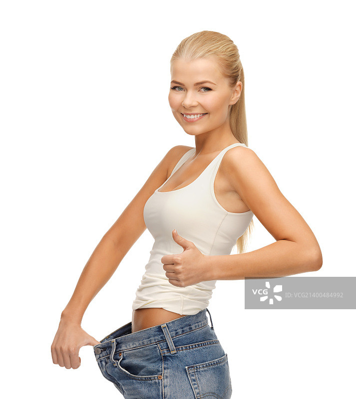 穿着运动装的女人展示宽松的裤子并竖起大拇指图片素材