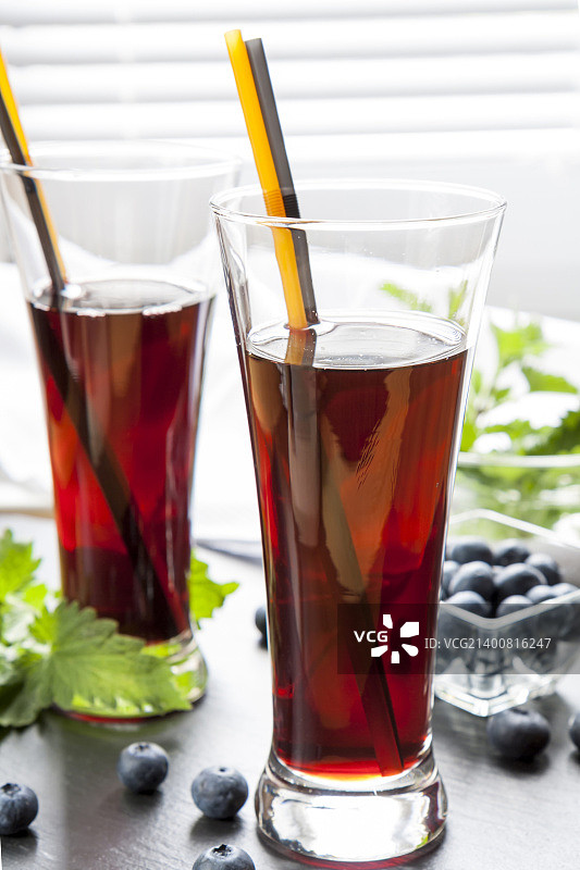 装有新鲜黑加仑汁、沼泽蓝莓和柠檬的玻璃杯图片素材