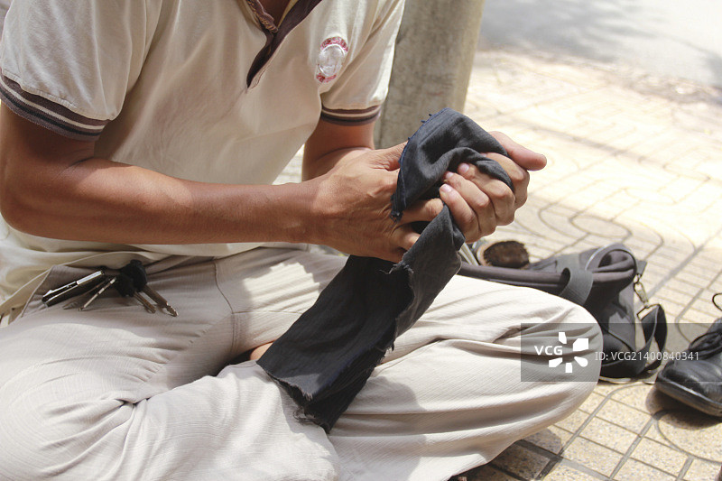 手擦亮黑色皮鞋图片素材