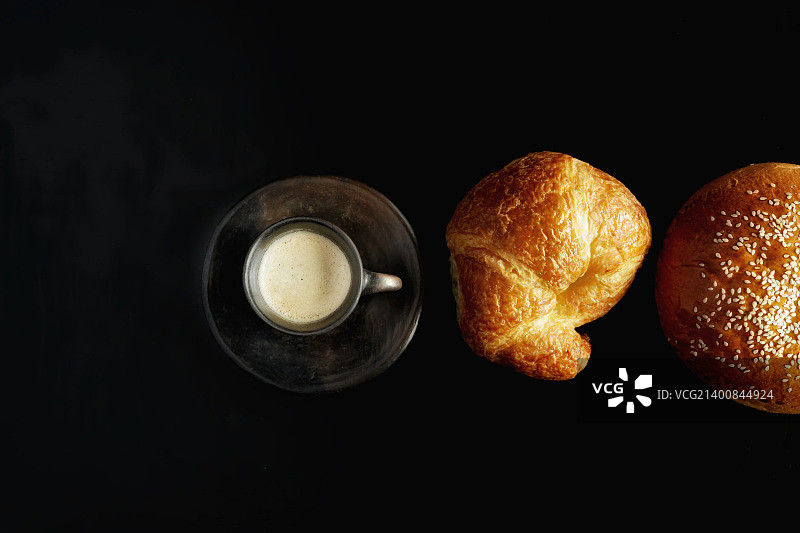 黑色桌子上放着糕点的浓缩咖啡图片素材
