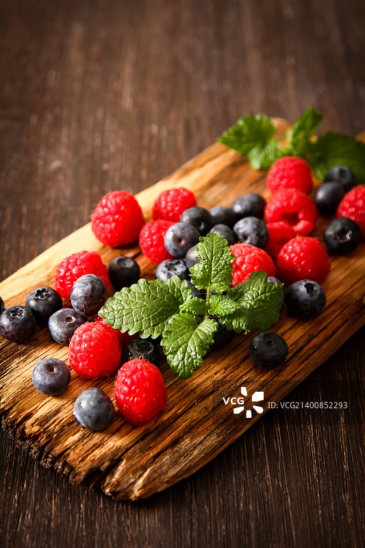 木板背景上的蓝莓和覆盆子图片素材