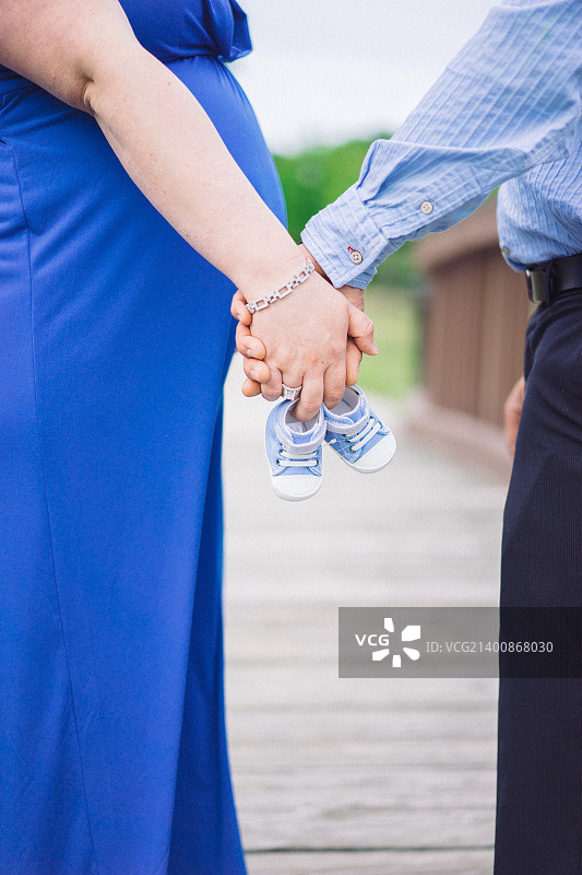 情侣牵手拿着婴儿鞋图片素材