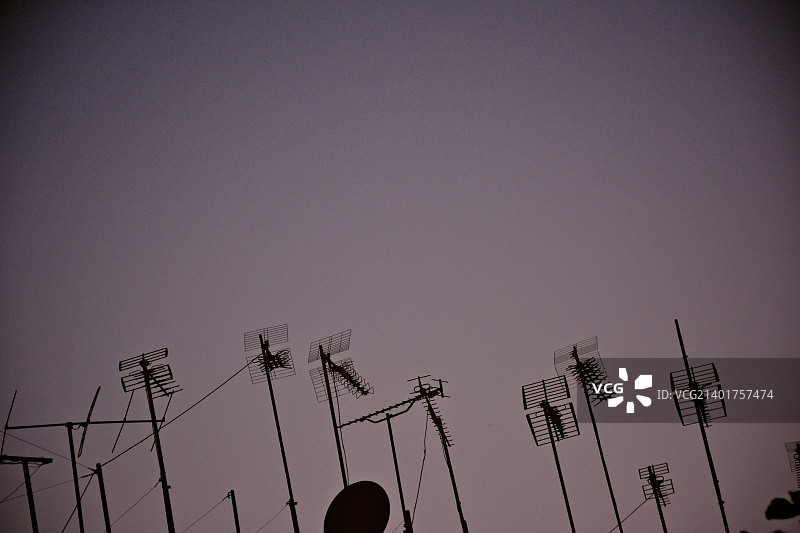 日落时分，晴空下电力塔的剪影低角度视图图片素材