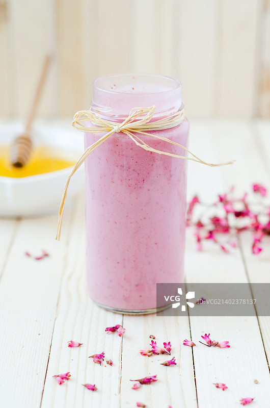 装在复古罐子里的粉色草莓冰沙与紫色鲜花图片素材