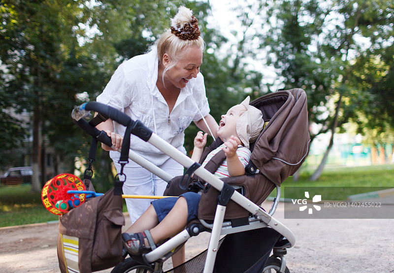 老奶奶在婴儿车里和孙子玩耍图片素材