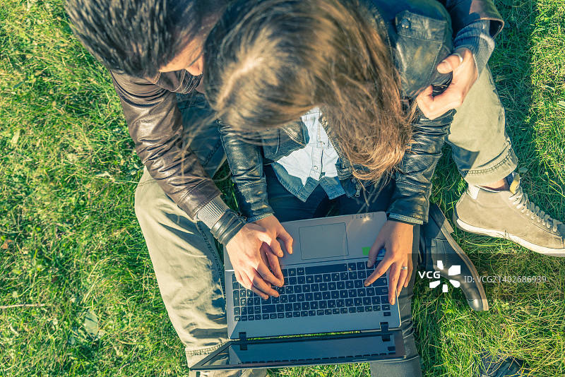 情侣在公园里看电脑图片素材